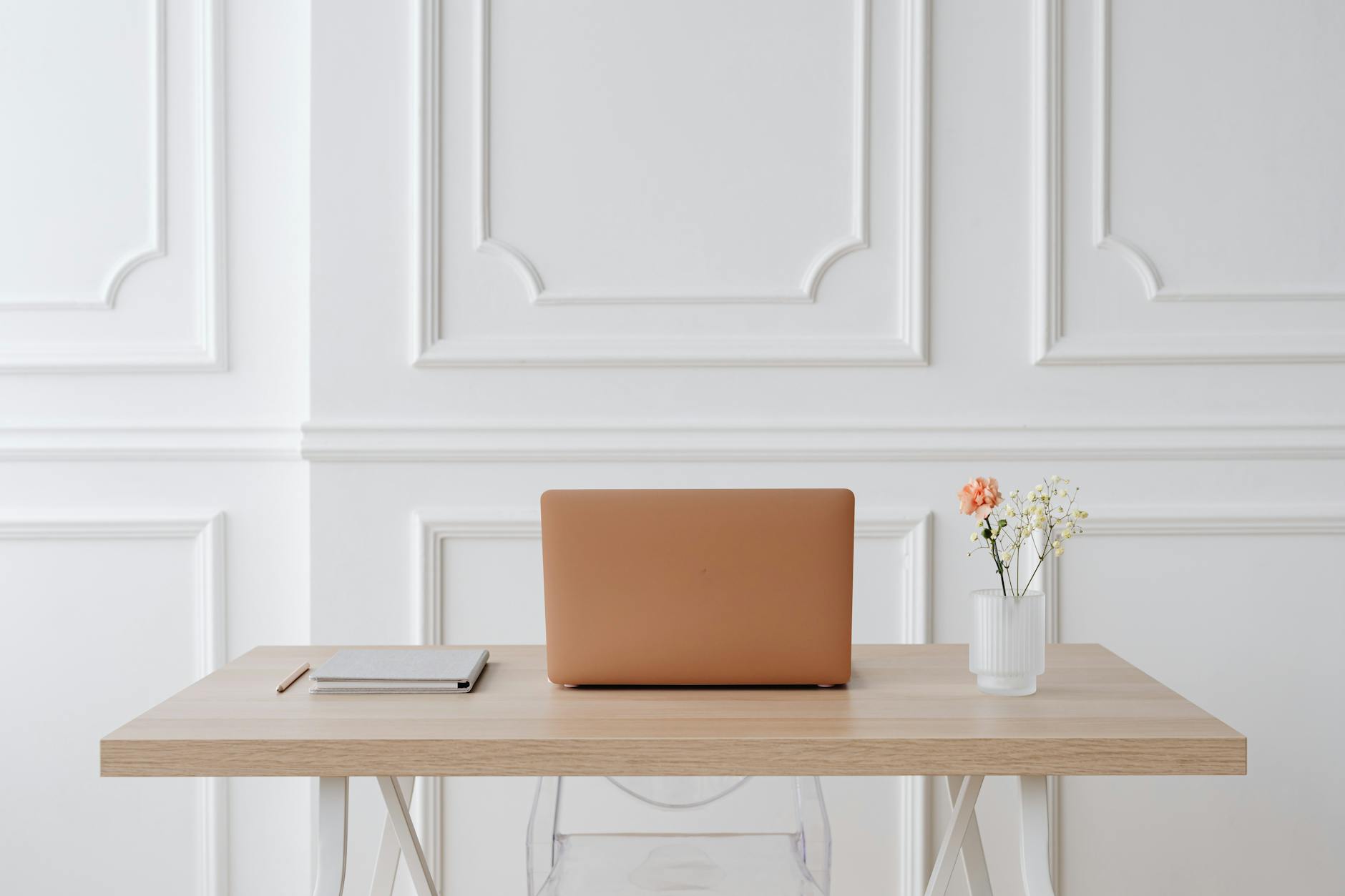 laptop and notebook on brown wooden table