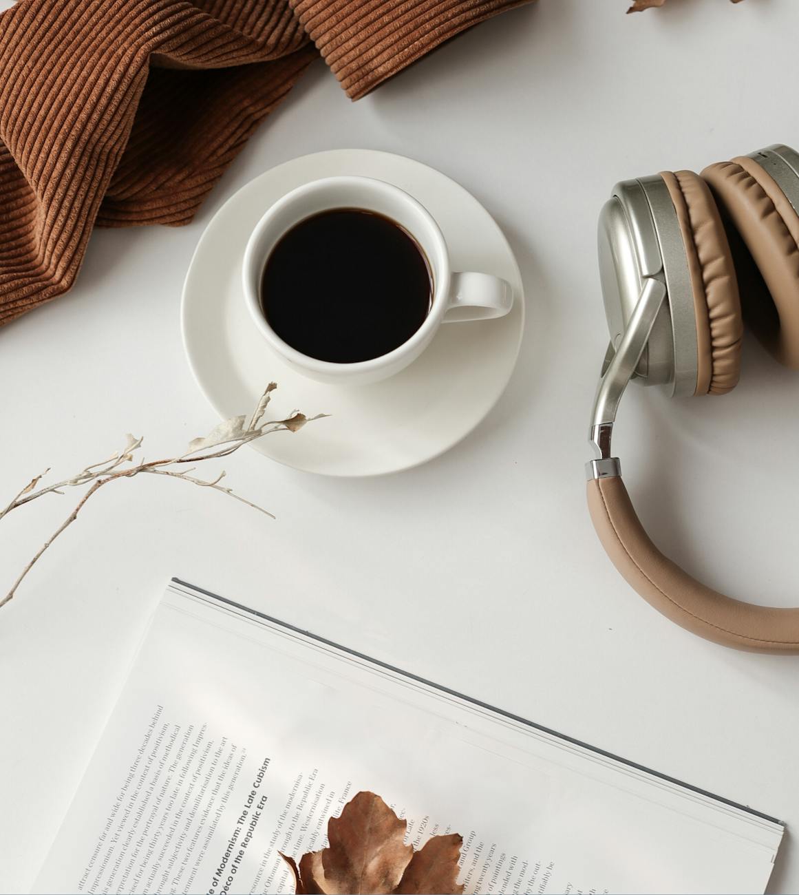 close up view of cup of coffee and headphones on desk